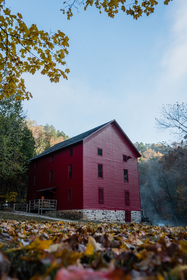 Red mill building surrounded by autumn leaves